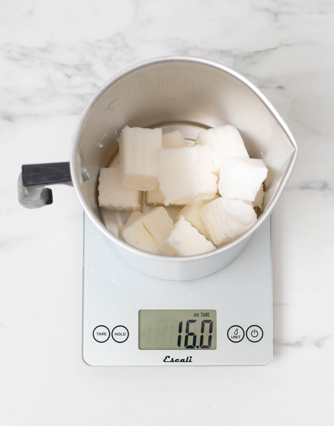 Wax in a pouring pitcher placed on a scale weighting 16 ounces.